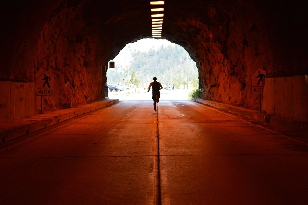 Hombre corriendo hacia la salida de un túnel